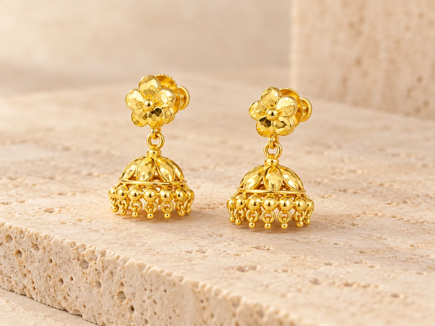 Pair of gold drop earrings with flower-shaped tops and dome-shaped lower parts with small hanging beads