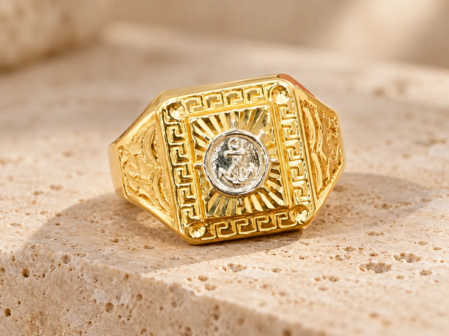 Gold signet ring with a Greek-key border around a silver-toned anchor