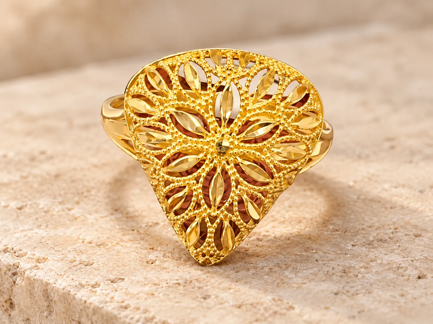 Gold ring with a broad flower-patterned filigree front